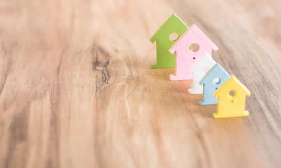 various_coloured_house_symbols_staying_in_one_line_on_brown_wooden_surface_sbi_318725811.jpg